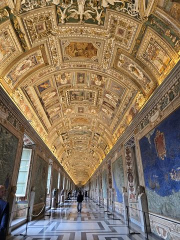 In this hall of maps, the artwork on the right and left site would be what you'd see if you walked atop the mountain ridge. Images on the ceiling are appropriate to the map depicted below it.