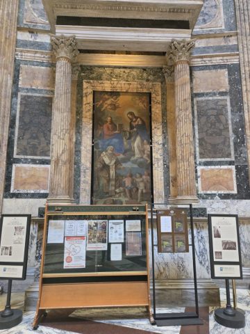 The "Pantheon St. Thomas Madonna of the Girdle" is a 1686 religious painting in the Pantheon in Rome depicting the legend of the Virgin Mary lowering her girdle to the Apostle Thomas. The painting is also known as the "Madonna of the Girdle" or "Madonna della Cintola," and alongside Thomas, it often features another saint, such as St. Nicholas of Bari, a typical 17th-century religious composition. The composition focuses on the Virgin Mary in heaven, dropping her belt to a skeptical Thomas on earth to prove her Assumption