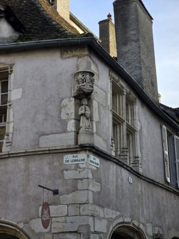 It was not uncommon for the corner of one's building/house to be reflective of their occupation - such as this winemaker, who's holding his grapes